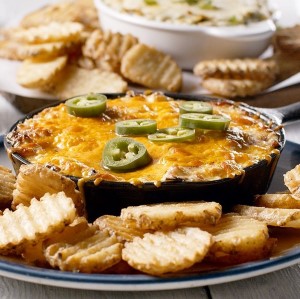 Cheesy dip with jalapeños on top with Cavendish Farms Crinkle Chips on the side.
